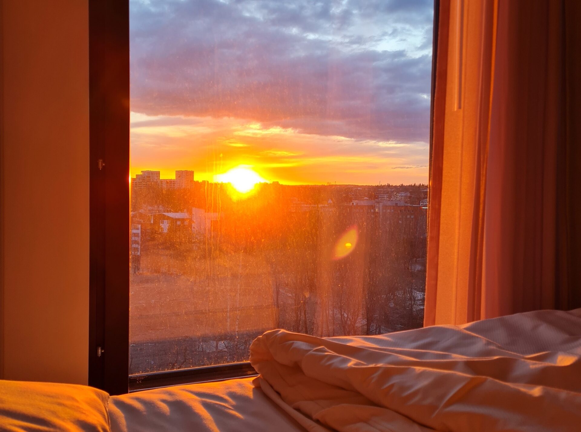 Auringonlasku hotellihuoneen ikkunasta
